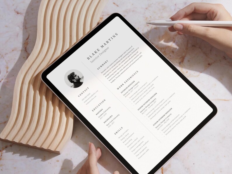 Op de afbeelding: Een digitale tablet waarop een cv voor Blake Martins, een interieurontwerper, wordt weergegeven. Het cv bevat secties voor samenvatting, contact, opleiding, werkervaring en vaardigheden.