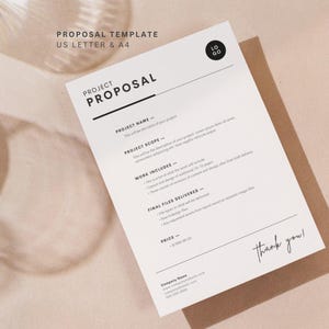 以下が含まれることがあります： プロジェクト名、スコープ、作業の詳細など、黒いテキストの白いプロジェクト提案テンプレート。 ドキュメントは茶色の封筒にあり、下部に「Thank you!」という言葉があります。 テンプレートには「US LETTER & A4」とラベルが付けられています。