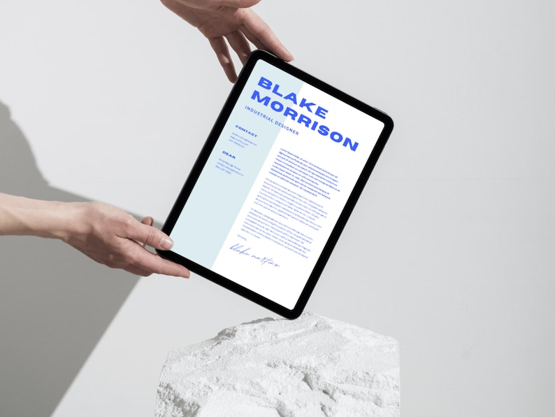 May include: A digital tablet displaying a CV for Blake Morrison, an Industrial Designer. The CV is on a white background with blue text. The tablet is held in the air by two hands.