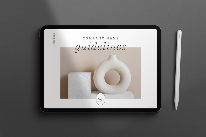 May include: A digital tablet displaying a company branding guide with the text "COMPANY NAME guidelines" and a photo of a white ceramic vase with a ring-shaped opening on a beige background. The text "bg." is also visible on the screen.