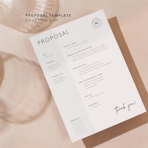 May include: A white proposal template with the title "PROPOSAL" in a minimalist design. The document includes sections for project details, scope, and investment, with the text "thank you!" at the bottom. The template is on a brown envelope.