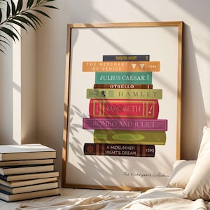 May include: A framed print featuring a stack of colorful books with titles like "Hamlet" and "Romeo and Juliet." The print is in a wooden frame and is leaning against a wall. The text "The Shakespeare Collection" is at the bottom.