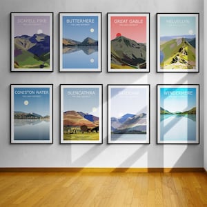 May include: A wall gallery of eight framed posters featuring illustrations of mountains and lakes in the Lake District, England. The posters are arranged in two rows of four, with each poster featuring a different mountain or lake. The posters are all in a black frame and have a white background.