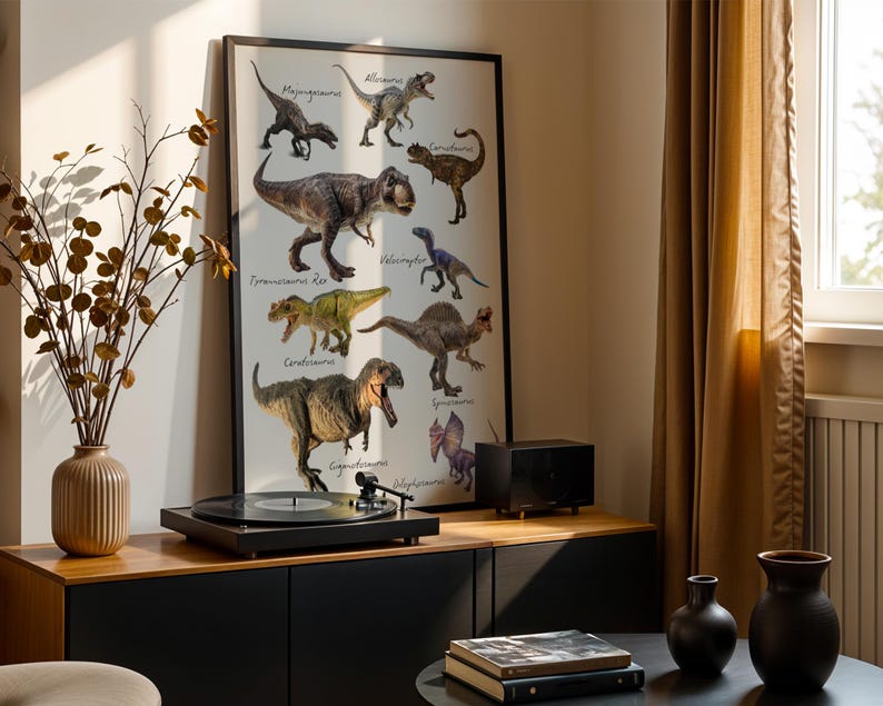 Op de afbeelding: Een ingelijste poster met gedetailleerde illustraties van diverse dinosaurussen, waaronder een Tyrannosaurus Rex, Velociraptor en Spinosaurus, waarbij elk wezen met zwarte schrijfletters op een witte achtergrond in een zwarte lijst is benoemd.