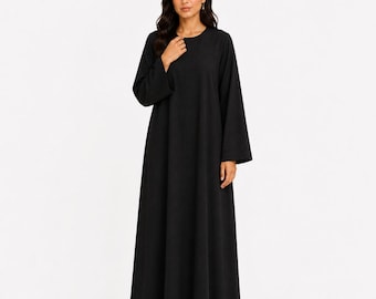 May include: A floor-length black dress with long, wide sleeves and a simple round neckline. The garment features a solid black color, a straight-cut silhouette that flows to the floor, and a plain, unadorned design throughout the entire piece.