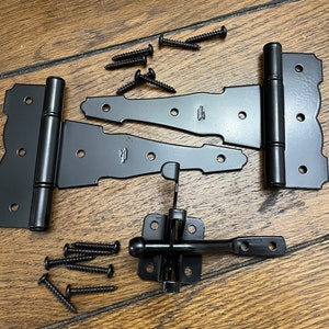 May include: Black metal gate hardware set with two hinges, a latch, and screws. The hinges have a decorative design and the latch has a round knob.