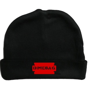 Puede incluir: Gorro negro con un gráfico de cuchilla de afeitar roja que dice "Dimebag".