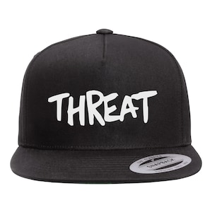 May include: Black and white baseball cap with the word "THREAT" written in white on the front. The cap has a black adjustable strap and a black snap closure.