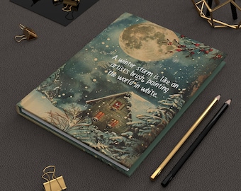May include: A green journal with a winter scene on the cover. The scene features a house, trees, and a full moon. The text on the cover reads: "A winter storm is like an artist's brush, painting the world in white."
