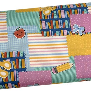 May include: A fabric print featuring a patchwork design of various patterns including stripes, polka dots, and grids. The pattern includes illustrations of books on shelves, yellow pencils, scissors, a smiling red apple, and a light blue bow.