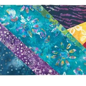 May include: A patchwork textile featuring various patterned fabric strips in shades of blue, purple, yellow, and red. The fabrics include floral, dotted, and abstract designs, creating a vibrant and colorful composition.