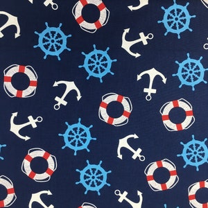 Op de afbeelding: Een donkerblauwe stof met een herhalend patroon van witte ankers, rood-witte reddingsboeien en blauwe stuurwielen.