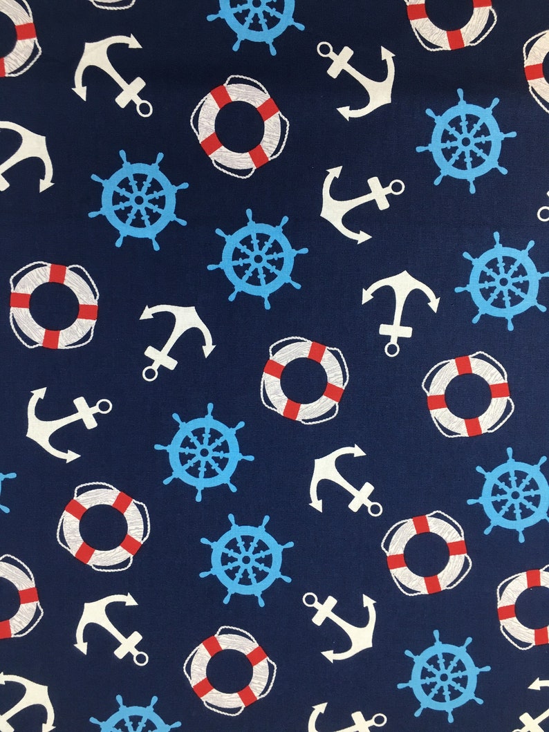 Op de afbeelding: Een donkerblauwe stof met een herhalend patroon van witte ankers, rood-witte reddingsboeien en blauwe stuurwielen.