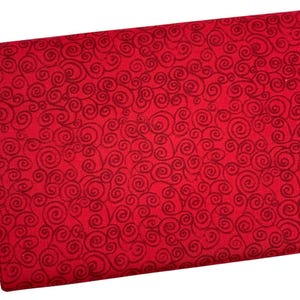 May include: A folded piece of red fabric with a repeating pattern of dark red swirls. The fabric appears to be a medium weight, suitable for various sewing projects. The design is a classic, elegant choice for apparel or home decor.