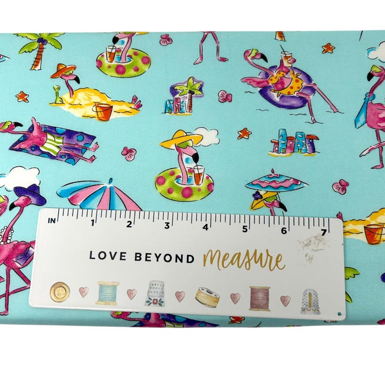 May include: A light blue fabric with a repeating pattern of pink flamingos in sunglasses and hats, enjoying tropical drinks and lounging on the beach. The fabric also features palm trees, umbrellas, and the text "LOVE BEYOND measure".