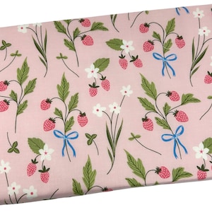 May include: Pink fabric with a repeating pattern of strawberries, green leaves, white flowers, and blue bows. The strawberries are red with small black seeds. The fabric is likely cotton or a similar material.