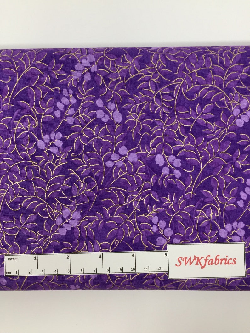 May include: Purple fabric with a gold leaf pattern. The fabric is 12 inches wide and has a ruler for measuring.