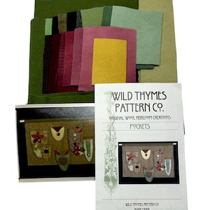 May include: A craft kit with various felt pieces in shades of green, burgundy, and yellow, along with a pattern booklet. The booklet features a design of decorative pockets. The text on the booklet reads "Wild Thymes Pattern Co."
