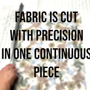 May include: A close-up of fabric being cut with a ruler. The text "FABRIC IS CUT WITH PRECISION IN ONE CONTINUOUS PIECE" is visible in the image.