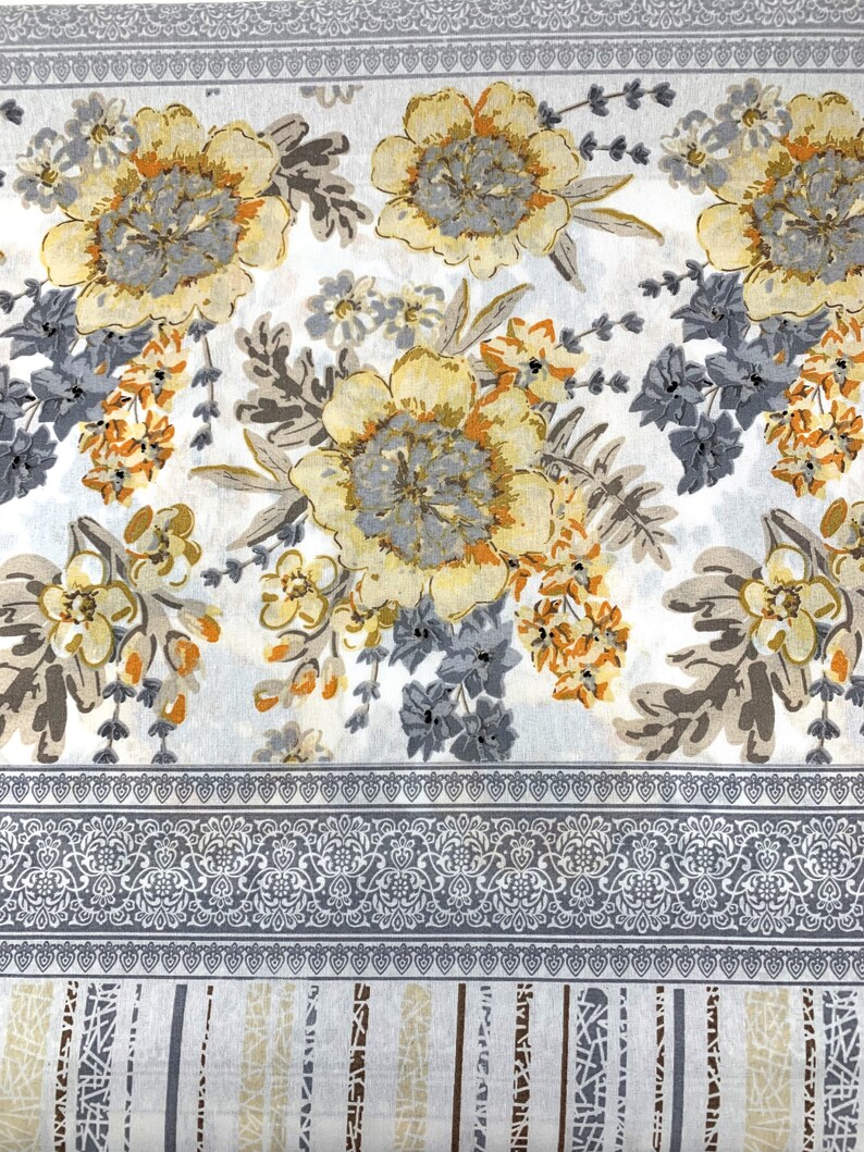 K&ouml;nnte beinhalten: Ein wei&szlig;er Stoff mit einem floralen Muster in Graut&ouml;nen, Gelb und Orange. Der Stoff hat einen grauen und wei&szlig;en Rand mit einem sich wiederholenden Muster.