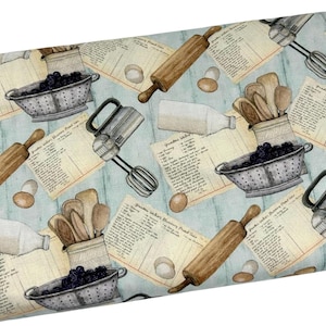 May include: A light blue fabric with a repeating pattern of baking-themed illustrations. The design includes rolling pins, hand mixers, colanders filled with berries, recipe cards, eggs, wooden spoons, and milk bottles.