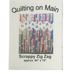 May include: A white paper pattern for a scrappy zig zag quilt. The pattern is titled "Quilting on Main" and the quilt is approximately 64 inches by 75 inches.
