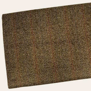 May include: A close-up of a brown fabric with a herringbone pattern and thin orange stripes.