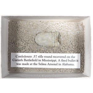 May include: A Confederate .57 rifle round recovered from the Corinth Battlefield in Mississippi. The fired bullet was made at the Selma Arsenal in Alabama.