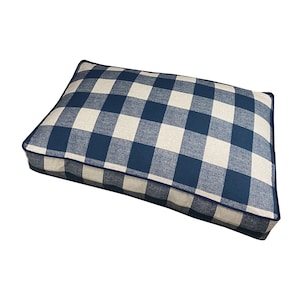 Op de afbeelding: Een blauw en wit geruit hondenbed met een donkerblauwe rand.