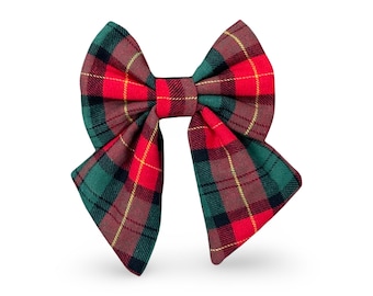 May include: A red and green plaid bow with a yellow and black plaid pattern. The bow is tied in a classic bow shape.