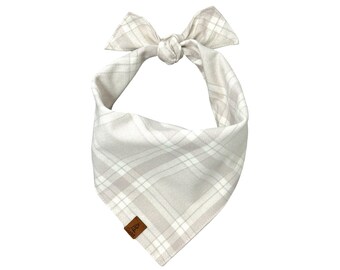 Bandana per cani in flanella a quadri alpini, con una stampa a quadri nei toni del tortora e del grigio tenue su tessuto di flanella di alta qualità. Personalizzabile con il nome del tuo animale domestico.