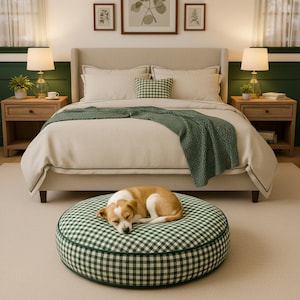 May include: A dog bed with a green and white gingham pattern, with a sleeping dog. The bed is round and has a green border. The bed is in a bedroom with a bed, side tables, and lamps.