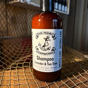 May include: A brown bottle of San Pedro Soapworks shampoo with a white label. The label says "Get Fresh. Get Clean." and features an anchor and the text "Shampoo Lavender & Tea Tree Sulfate-free Plant-based All-natural 16 fl oz (473 ml)"