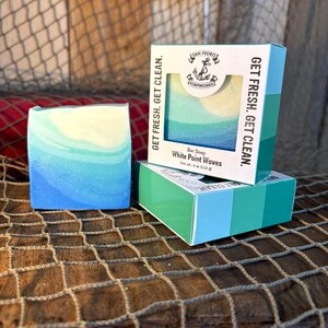 Puede incluir: Una pastilla de jabón con un diseño en espiral azul y blanco con el texto "White Point Waves" y "Get Fresh. Get Clean." en el embalaje. El jabón está empaquetado en una caja con un diseño azul, verde y blanco.
