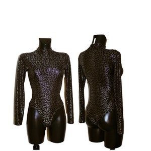 Op de afbeelding: Een zwart en zilveren bodysuit met een luipaardprint. De bodysuit heeft lange mouwen en een hoge hals.