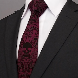 May include: A burgundy silk tie with a black skull and floral pattern.