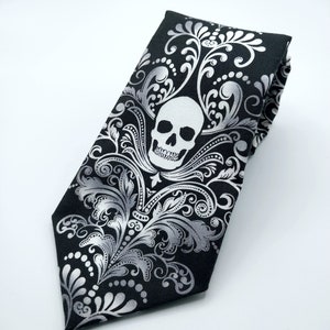 May include: A black tie with a silver skull and floral pattern.