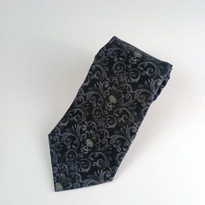 May include: Black tie with a white skull and floral pattern.