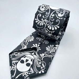 May include: A black tie with a white skull and floral pattern.