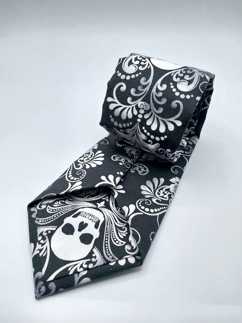 May include: A black tie with a white skull and floral pattern.