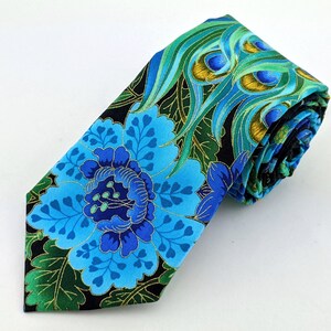 May include: A blue and green silk tie with a floral and peacock feather pattern. The tie is rolled up and ready to be worn.