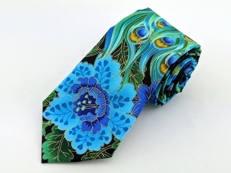 May include: A blue and green silk tie with a floral and peacock feather pattern. The tie is rolled up and ready to be worn.