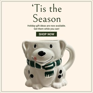 May include: White ceramic mug shaped like a dog wearing a green and white scarf. The mug has black spots and a pink tongue sticking out. 'Tis the Season' text is above the mug.  Holiday gift ideas are now available. Get them while you can! SHOP NOW