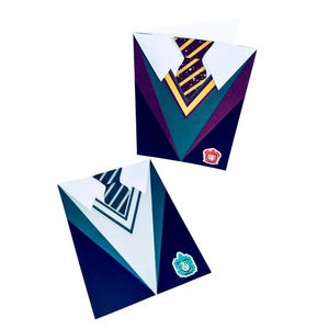 May include: Two folded cards with a Hogwarts house crest and a tie design. The card on the left has a blue, green, and white tie with a blue and white striped pattern. The card on the right has a yellow, green, and purple tie with a yellow and gold striped pattern.