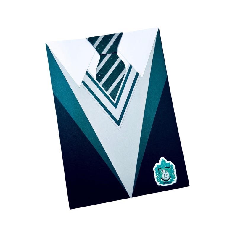 May include: A green, blue, and white paper card shaped like a school uniform with a tie and a crest. The crest is a green snake with a crown on its head.