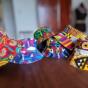 Peut inclure: Quatre chapeaux bucket colorés avec différents motifs géométriques et floraux. Les chapeaux sont en tissu et ont une large bordure.