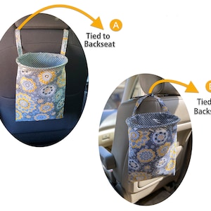 May include: Two gray and yellow floral fabric trash bags hanging from the headrests of car seats. The bags are tied to the headrests with fabric straps. The text "Tied to Backseat" is written next to each bag.