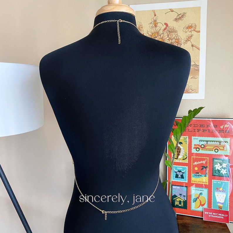 The back of a body chain on a mannequin with chain around the waist and neck