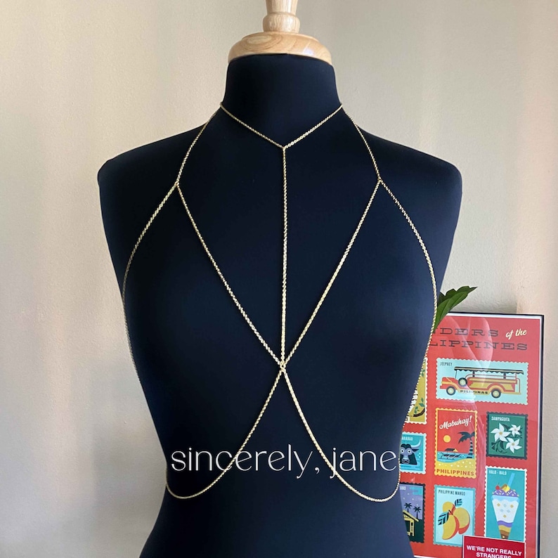 A body chain featuring a central chain and a neck chain elegantly displayed on a mannequin