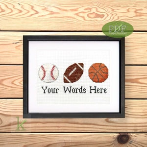 Peut inclure: Un motif de point de croix représentant un ballon de baseball, un ballon de football américain et un ballon de basket-ball. Le motif est encadré et comprend le texte "Your Words Here".